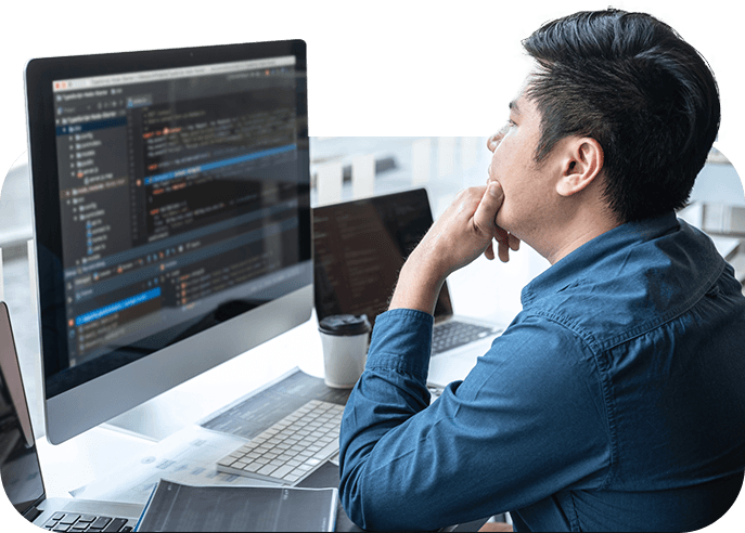 A man sitting at a desk with a computer screen, featuring Choose My Site Digital Marketing and aligning with data-driven online marketing solutions.